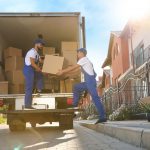 Workers,Unloading,Boxes,From,Van,Outdoors.,Moving,Service
